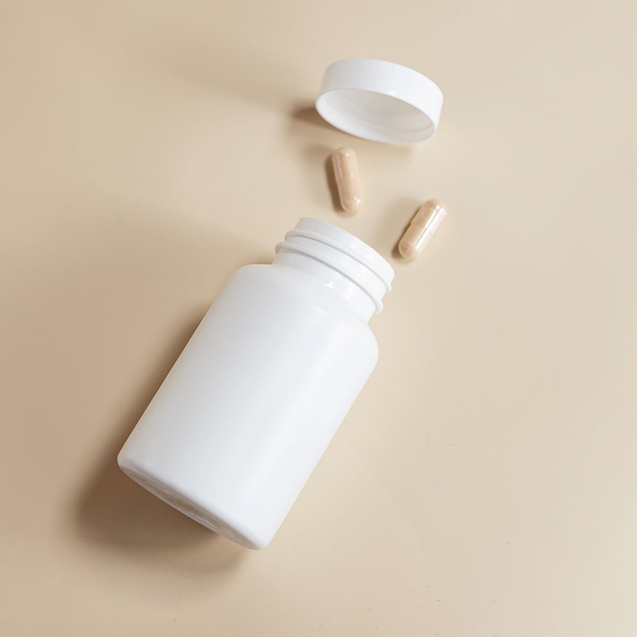 Clean minimalist supplement bottle on a soft beige background